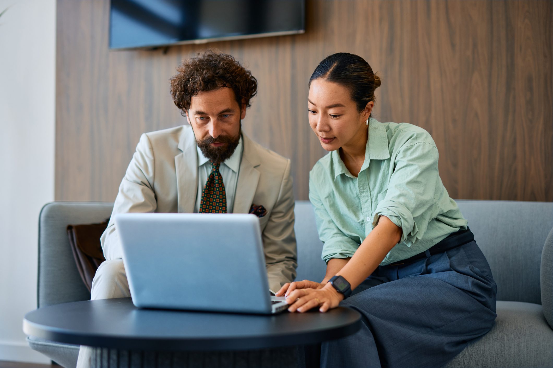 Colleagues discussing work on laptop