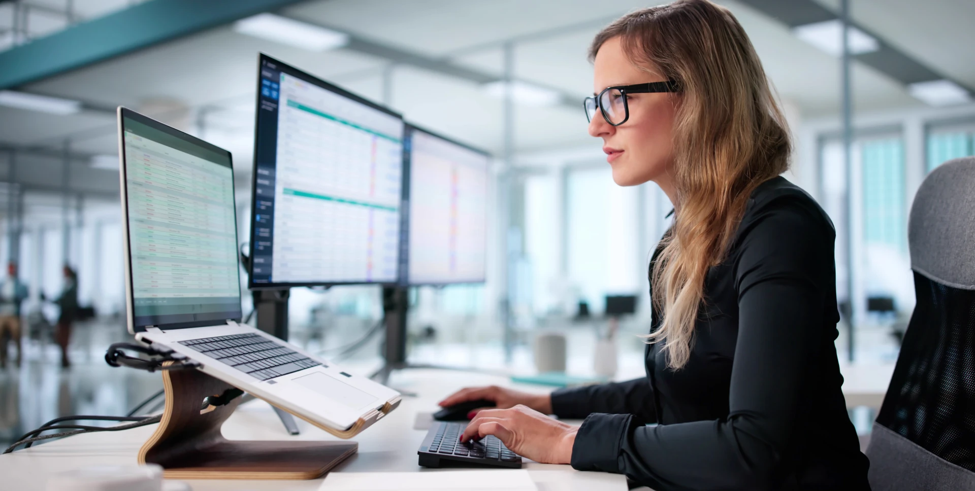 Woman working at dual monitors in office
